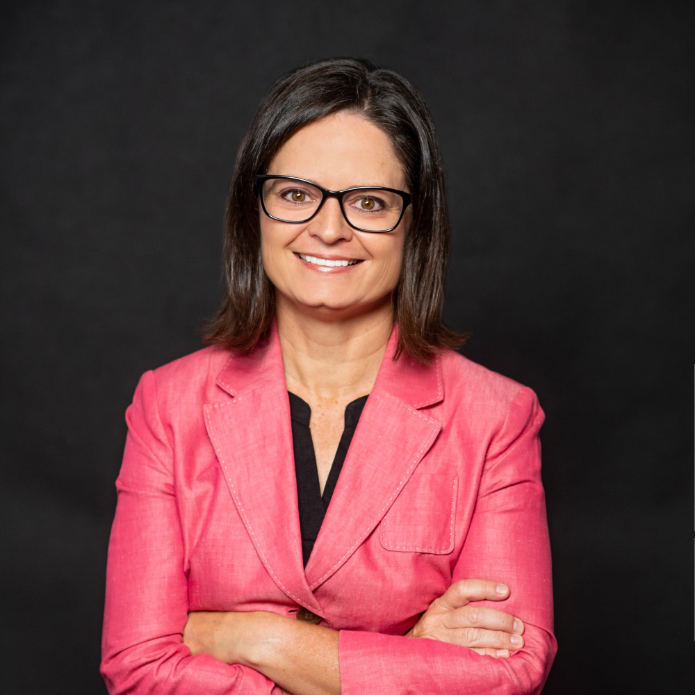 Image of a professional woman in a pink suit smiling