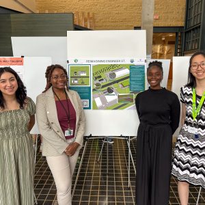 Four members of the Hopkins team pose for a photo next to the poster at the ASCE competition.
