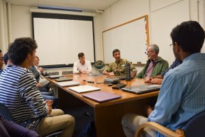 NATO colonel in uniform speaks with a group of Hopkins undergraduate students in a small classroom.