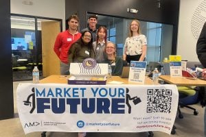 Hopkins students standing behind a "Market Your Future" banner.