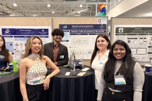 IRIS team members in front of their research poster with their HopStart trophy at Design Day 