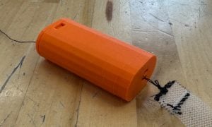 The 3D-printed prototype of the linear adjustment region with a black string attaching to the sling's wire mesh. 