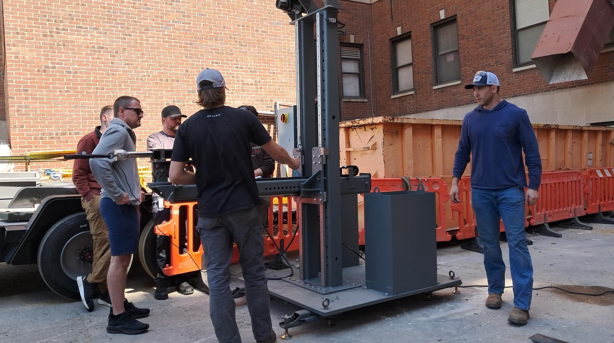 Four members of the team stand around a large steel welded structure.