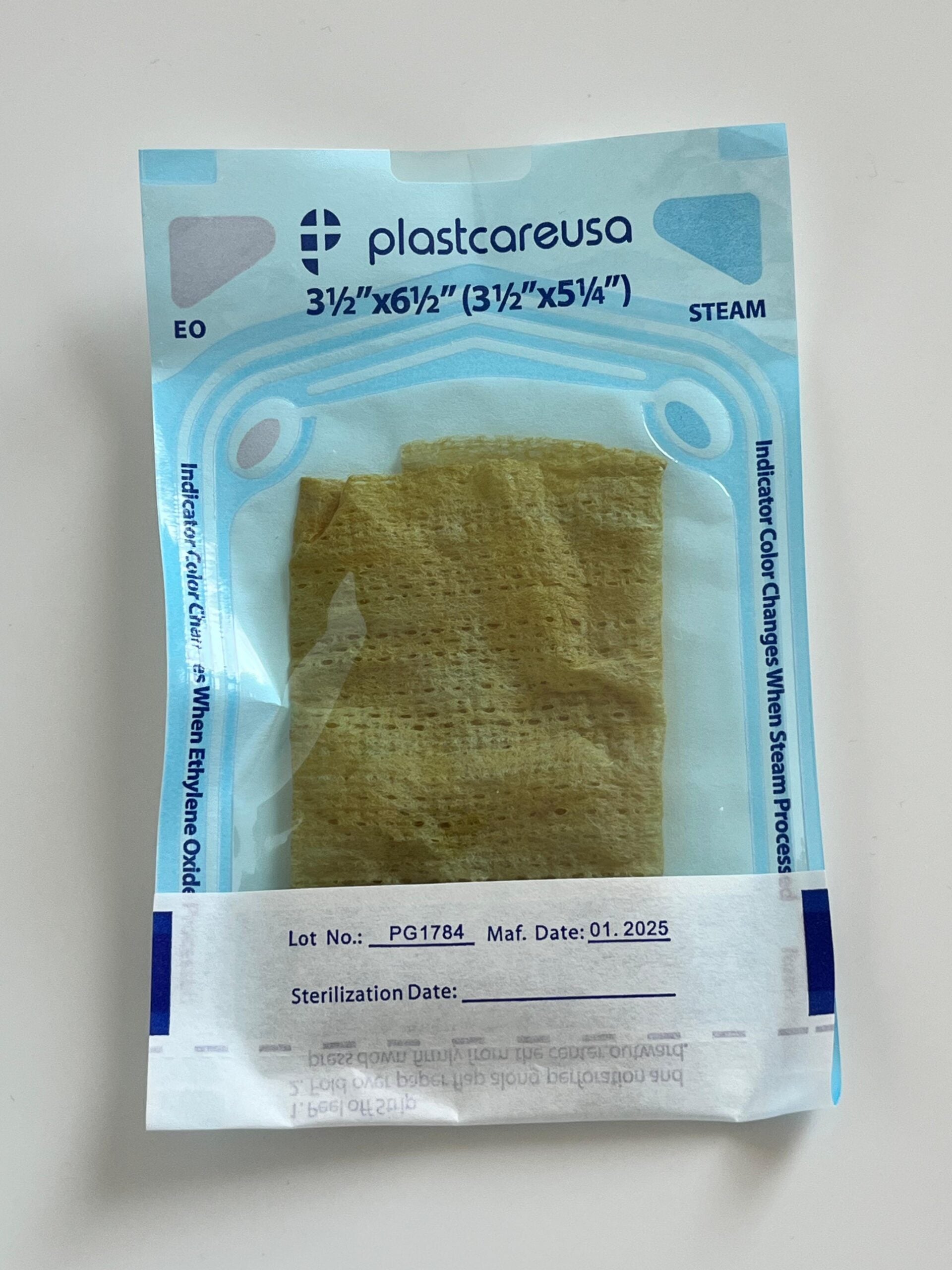 Packaged silver-treated gauze prototype inside a clear sterile pouch with blue labeling, shown on a white surface.