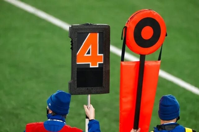 Neon orange down marker and down indicator box on a football field