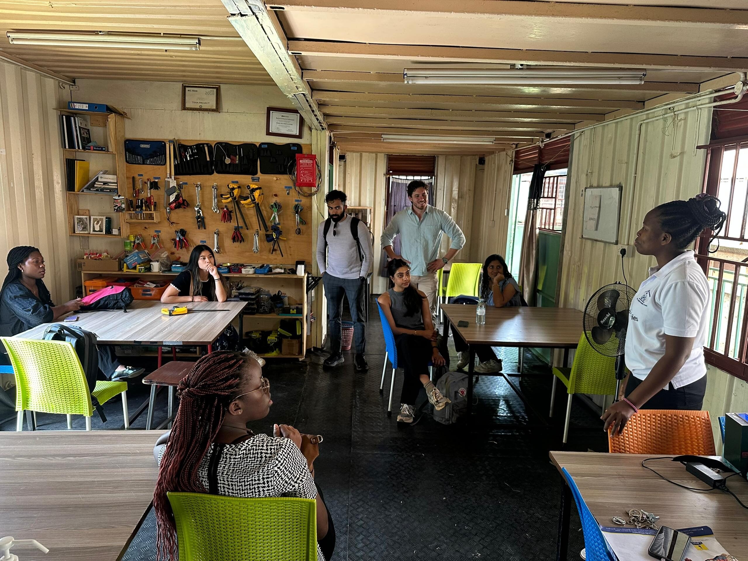 A photo of the Ekyaalo Diagnostics team speaking to Makerere University BME students in Uganda while conducting field research.