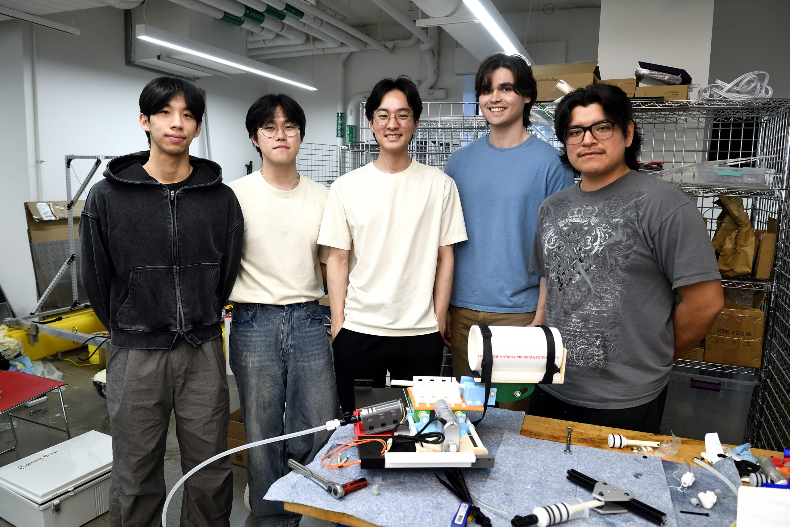 Five members of the KENNEDY design team standing in front of their prototype