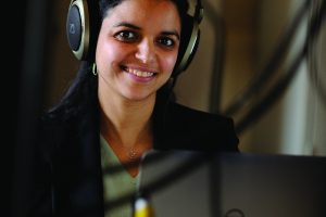 Photo of professor Mounya Elihali wearing headphones
