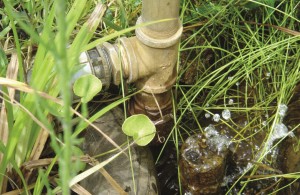 Located in the stream bed below the village, the almost maintenance-free ram pump has a vertical pipe—a pressurized chamber that feeds the reservoir. The design includes a modified check valve (on right), which periodically rams water back into the compression chamber.