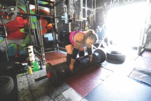 Amy Weldon squats to the ground in preparation for lifting a heavy weight