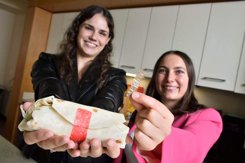 Tastee Tape inventors holding their adhesive-strip invention and a sealed burrito