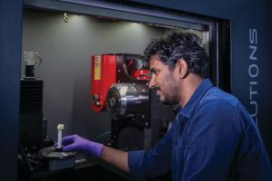 Image of a man inserting dried mitochondria to be scanned in the micro-CT, a 3D images scanner