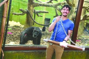 Photo of Greg Wulffen in front of a chimp enclosure at a zoo