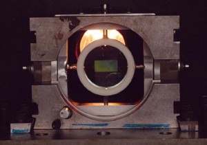 The gun fires a projectile that is precisely angled to meet a mirrored disc inside the chamber.