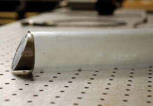 This polymer projectile has an angled metal flyer plate which, upon impact, creates a pinching and tangential force against the target.