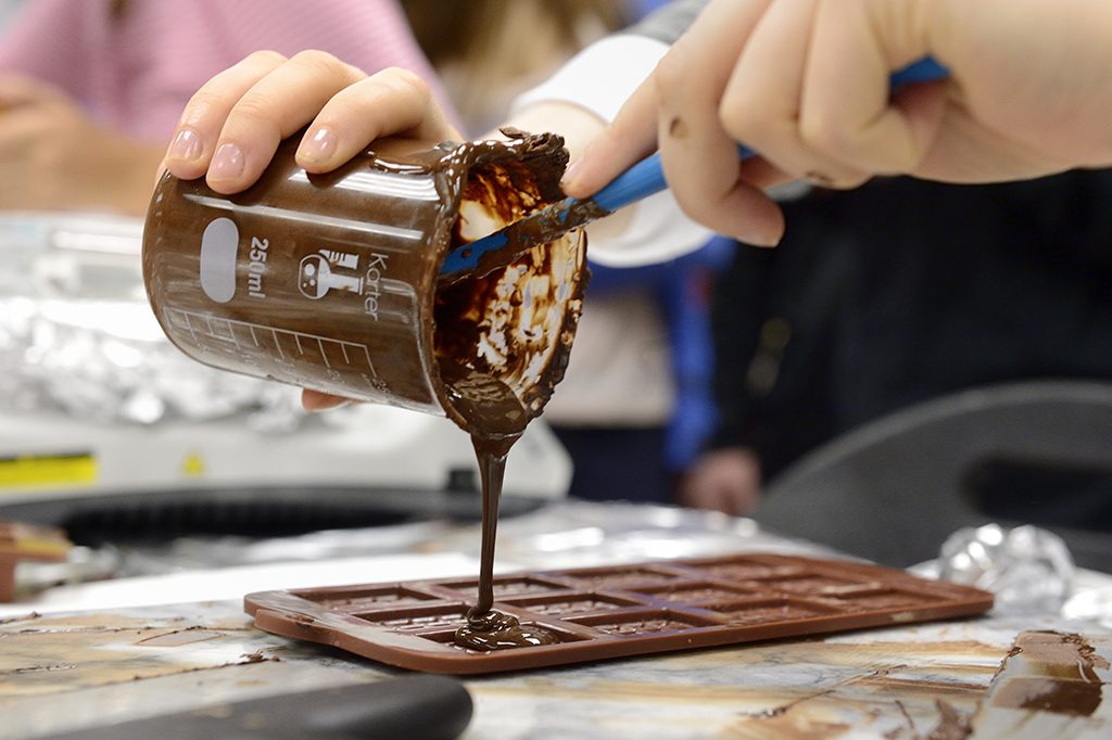 a photo of someone pouring chocolate into a mold 