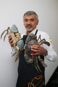 Dharshan Munidasa holds up two large crabs