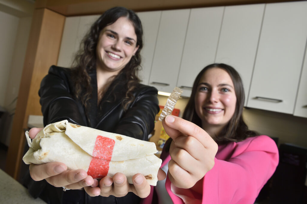 Tastee Tape inventors holding their adhesive-strip invention and a sealed burrito