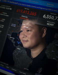 Photograph of Ensheng Dong with computer code superimposed over his face