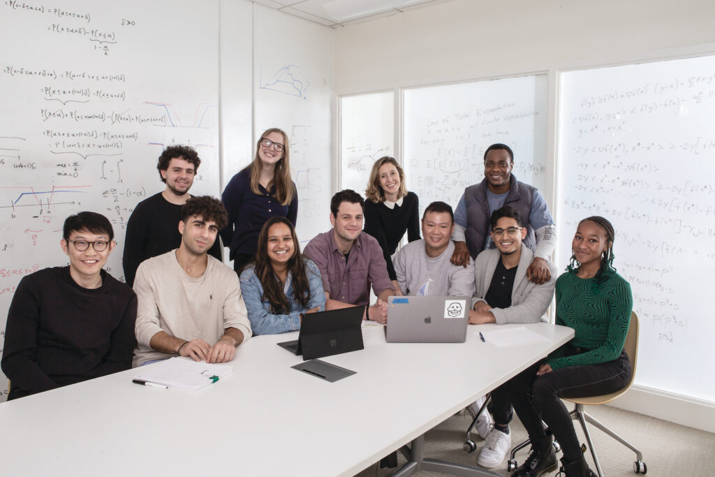 Lauren Gardner and her students seated around a conference table