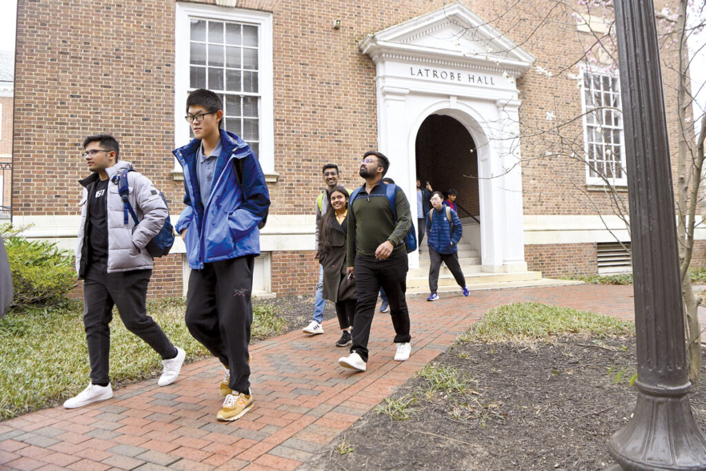 Group of students walking in front of Latrobe Hall on Hopkins' campus.