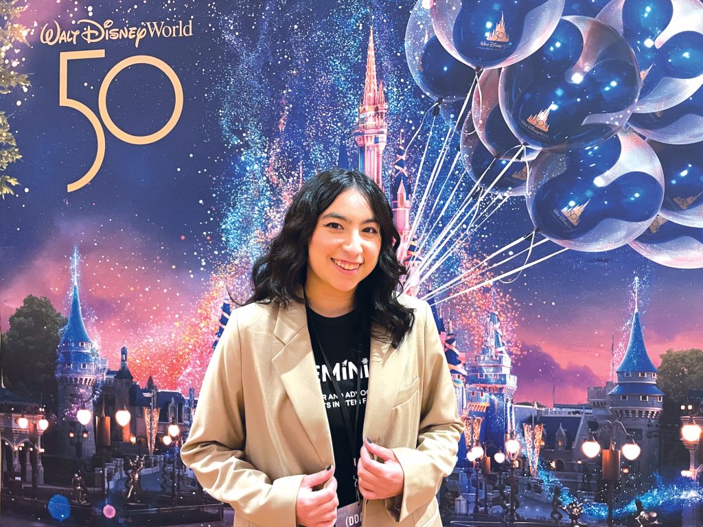 Corlay Sanmiguel standing in front of a Walt Disney World backdrop at Disney’s Data & Analytics Conference.
