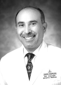 grayscale head shot of Peter Abadir wearing a lab coat