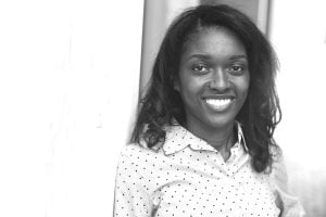 grayscale image of Bisi Bell wearing a polk-a-dot blouse