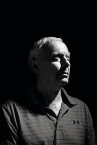 A black-and-white portrait of Alan Yuille in shadow with a spotlight on half of his face