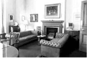 black-and-white image of a living room with furniture including couches and a fireplace