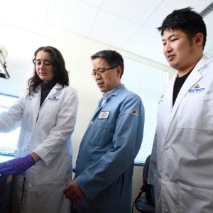 Hai Quan Mao and two students in the lab