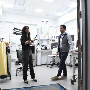 Two people in a white room.