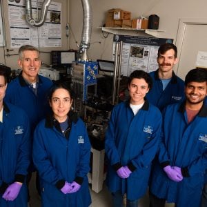 Seven people in blue coats looking at the camera.