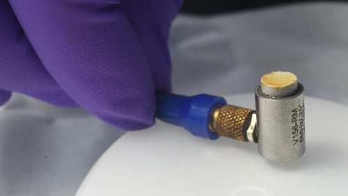 Tiny cylinder attached to a metal object.