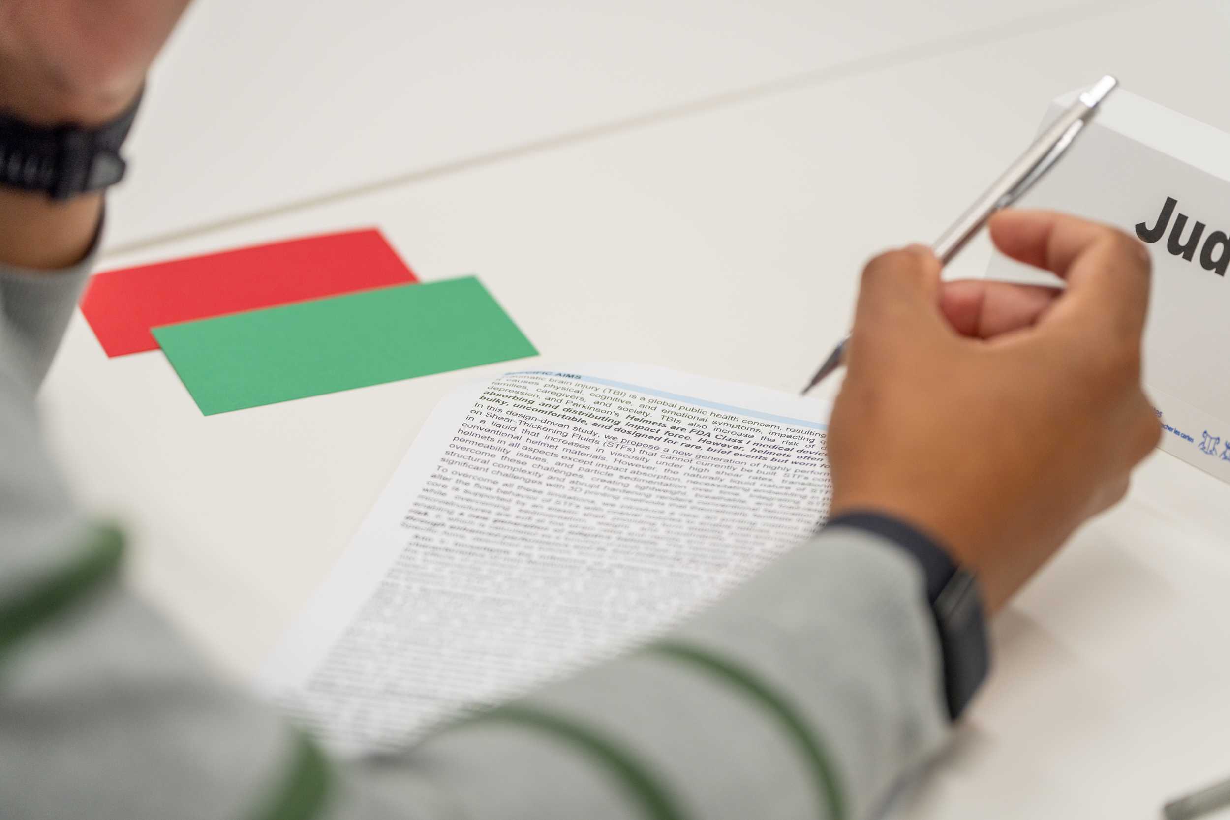 Closeup of a participant at the Advanced Grant Writing Working holding a pen above paper.