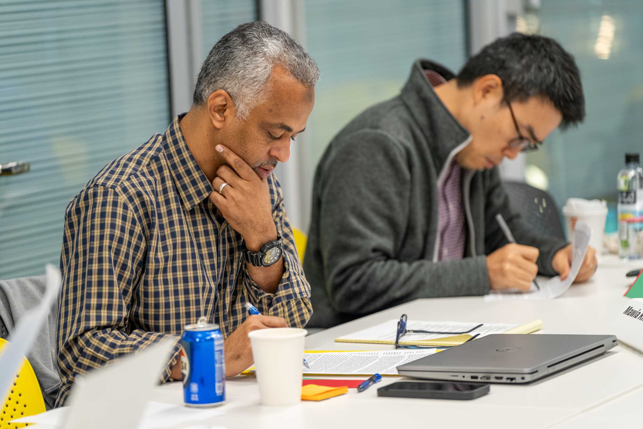 Two participants at the Advanced Grant Writing Workshop sitting at a conference table while working on a writing activity.