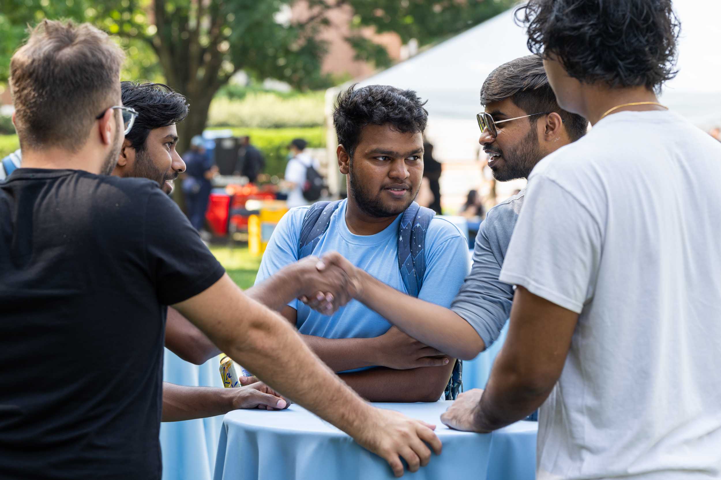 Students shaking hands at the graduate welcome event