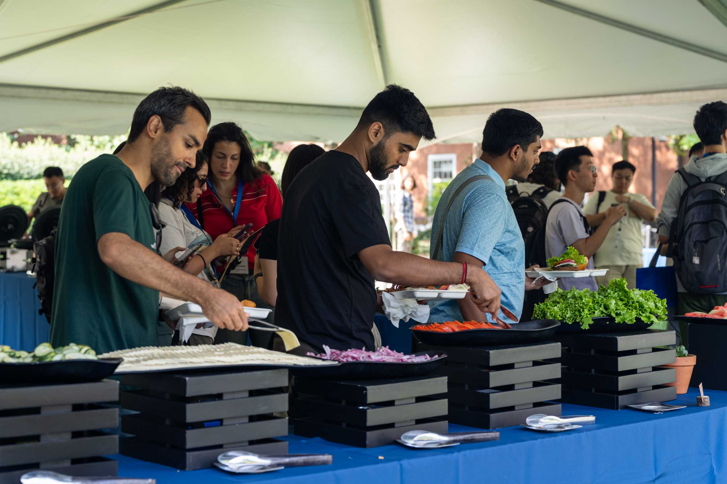 Attendees of the 2024 graduate welcome lunch standing in a food line.