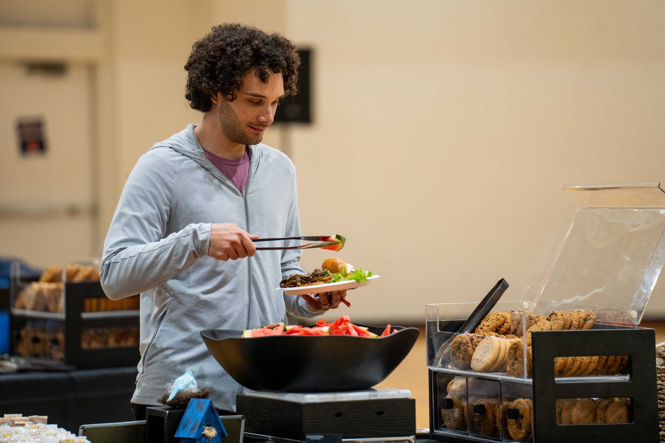 Attendee at the Masters graduate barbecue dishing watermelon onto a plate
