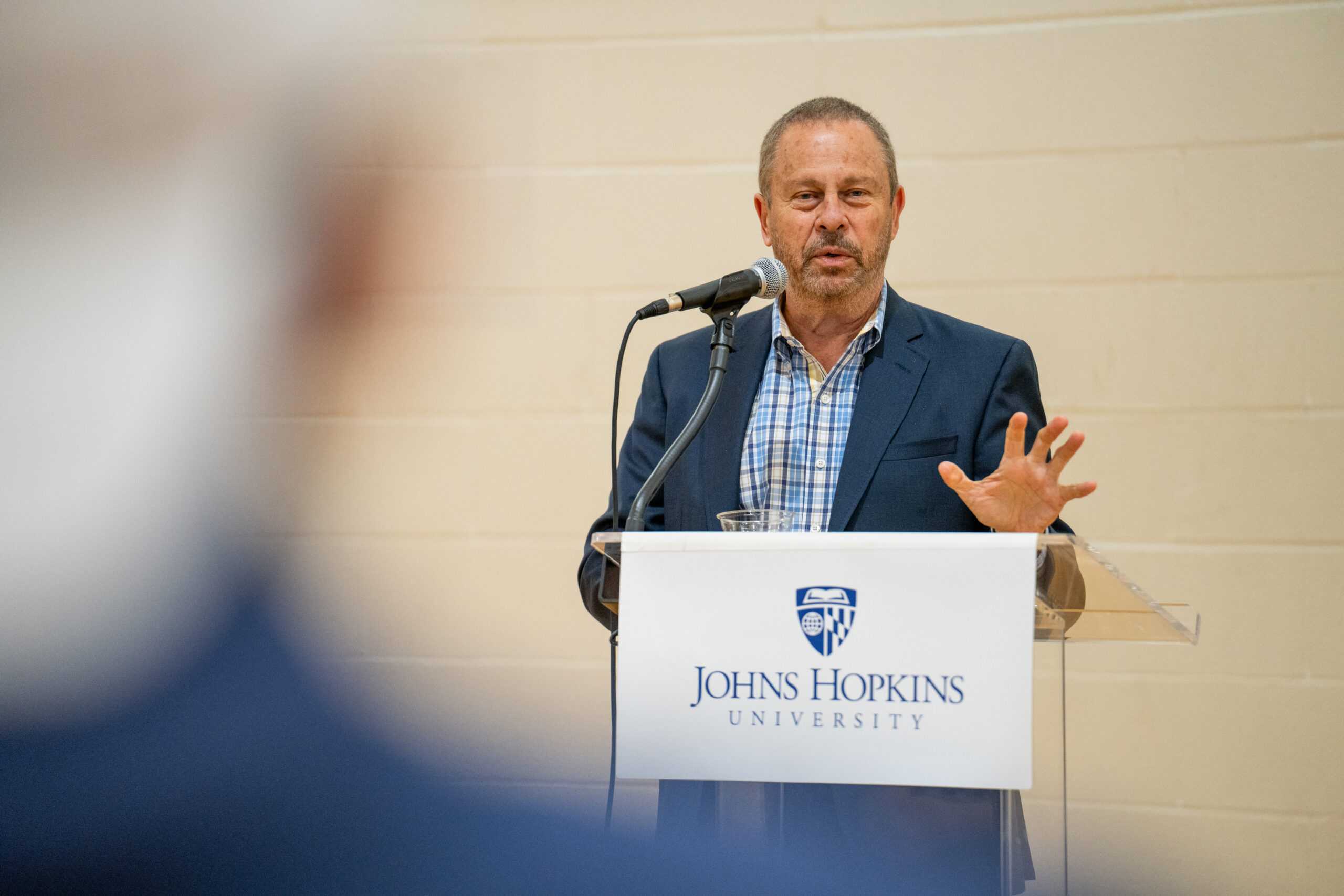 Dean Ed Schlesinger standing at a lectern while addressing the attendees of the Masters Graduate BBQ party.