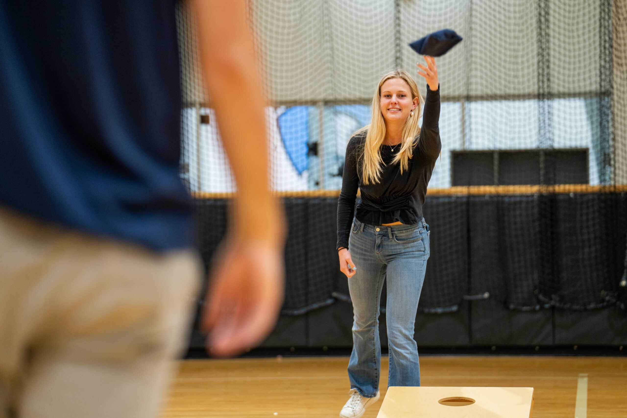 Attendee playing cornhole at 2024 Masters graduate BBQ.