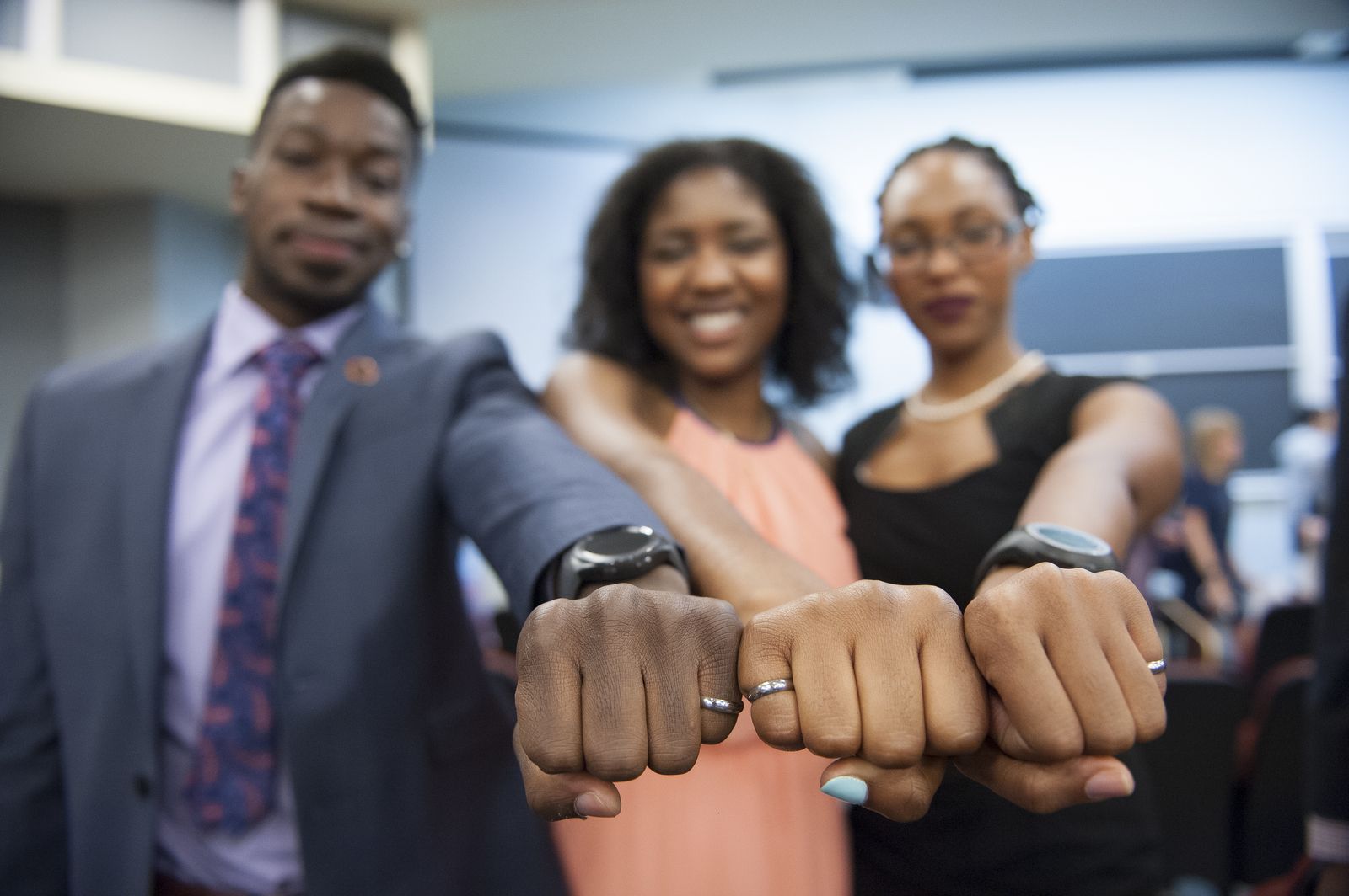 Three students holding their firsts out with their Order of the Engineer rings on.