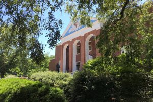The side view through the bushes of the Shriver Hall on the campus.