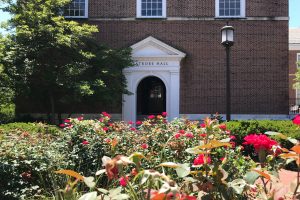 View of the Latrobe hall entrance on the campus, with flower bed in front of it.