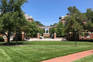 Outdoors of the campus with one of the campus buildings in the background.