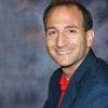 A headshot of Joshua Doloff in a blazer