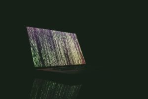 A laptop screen displaying an abstract picture with dark background.