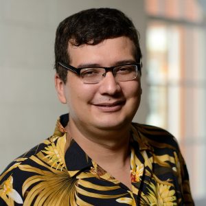 A headshot of Najim Dehak wearing a tropical print black shirt