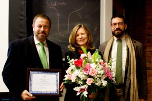 Eileen Haase receiving an award and a bouquet of flowers.