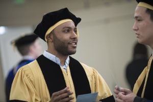A Johns Hopkins engineering PhD graduate wearing the traditional graduation robes for doctoral students